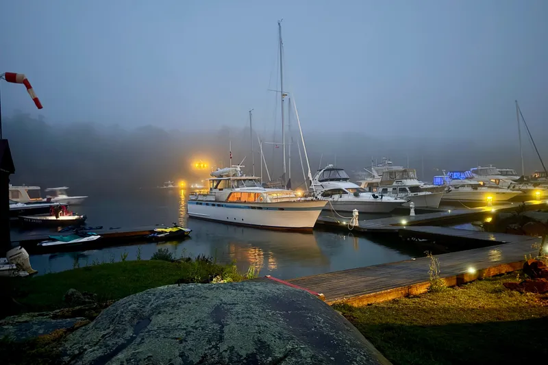 Slide: The Image of 1962 Chris-Craft 55 Commander yacht docked in a foggy marina at dusk. - 19
