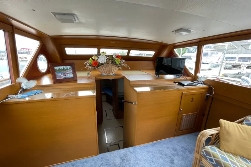 Slide: The Image of Interior of a 1962 Chris-Craft 55 Commander yacht with wood paneling and floral decor. - 38