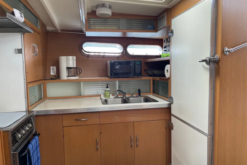 Slide: The Image of 1962 Chris-Craft 55 Commander kitchen with wooden cabinets, sink, and appliances. - 28