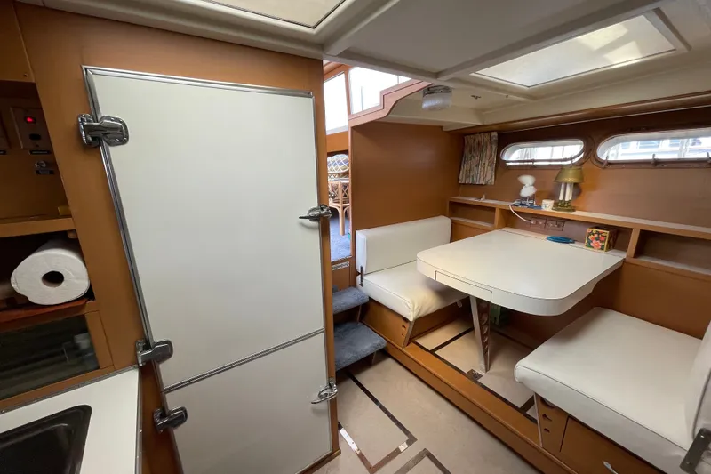 Slide: The Image of 1962 Chris-Craft 55 Commander interior with dining area, white seating, and vintage decor. - 33