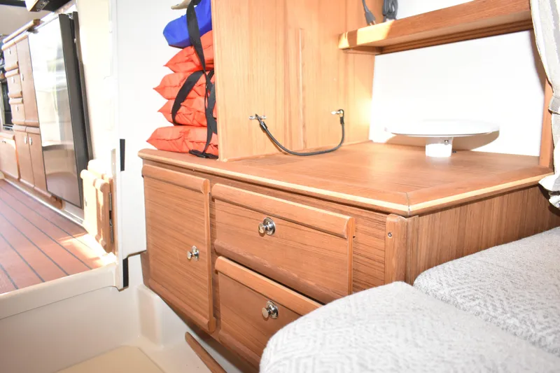 Slide: The Image of 2024 Ranger Tugs R-27 interior with wooden cabinetry and life jackets. - 46