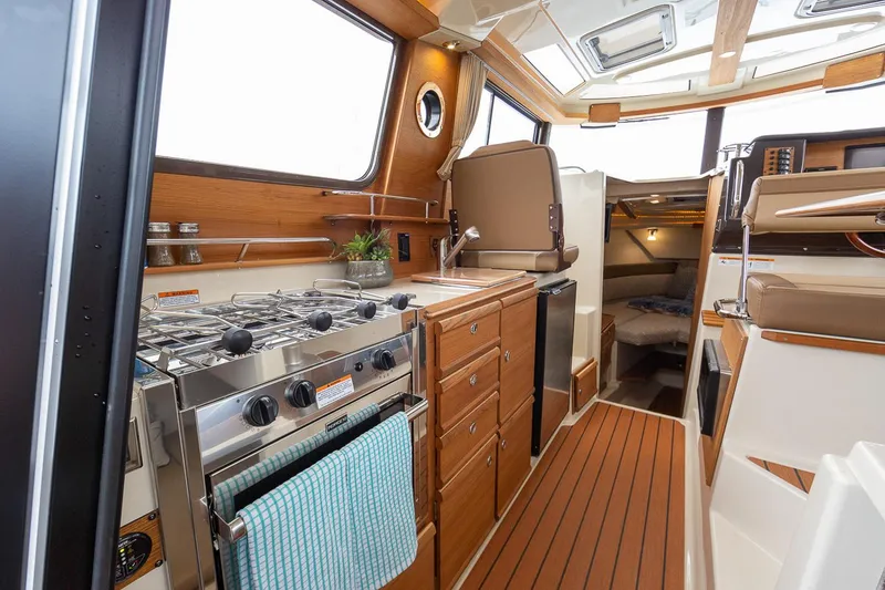 Slide: The Image of Manufacturer Provided Image: 2024 Ranger Tugs R-27 interior with modern kitchen and cozy cabin space. - 57