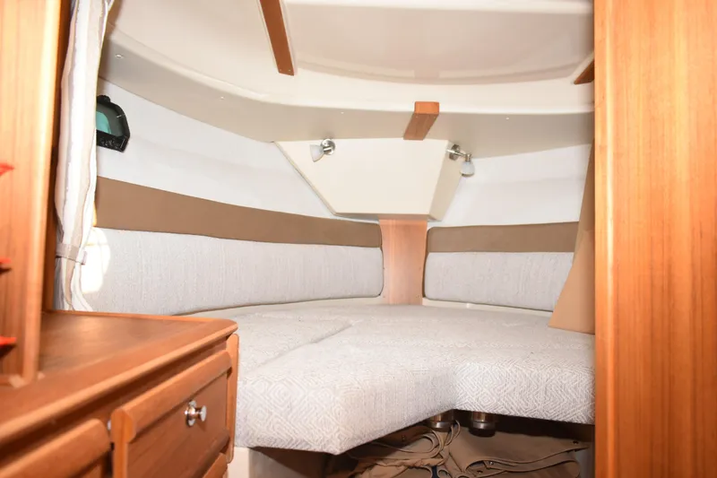 Slide: The Image of 2024 Ranger Tugs R-27 interior cabin with cozy seating and wooden accents. - 42
