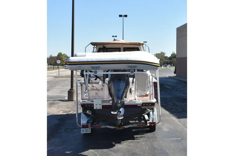Slide: The Image of 2024 Ranger Tugs R-27 boat rear view with outboard motor and inflatable dinghy. - 11