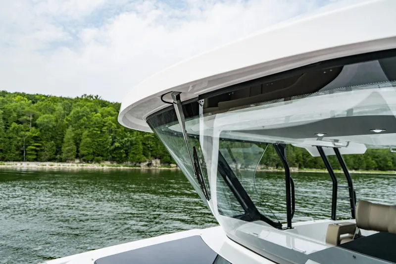 Slide: The Image of The 2027 Cruisers Yachts 38 VTR EC on a calm lake with a wooded shoreline. - 32