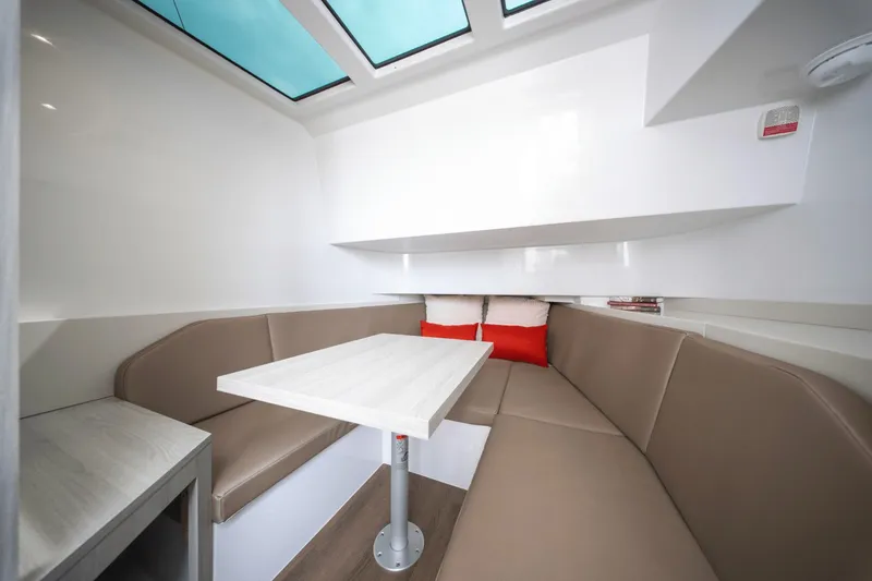 Slide: The Image of Interior of a modern yacht with beige seating area and white table under a glass ceiling. - 22