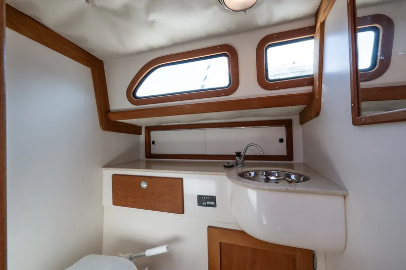 Slide: The Image of Interior of a 2009 Morris M36 yacht bathroom with wooden accents and stainless steel sink. - 46