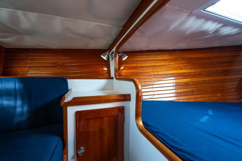 Slide: The Image of Interior of 2009 Morris M36 sailboat with polished wood paneling and blue upholstery. - 42
