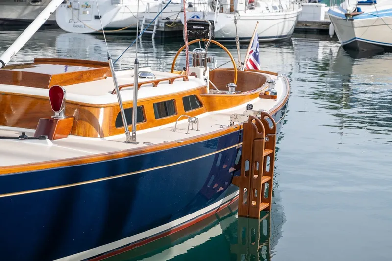 Slide: The Image of Elegant 2009 Morris M36 sailboat docked, featuring classic wooden accents and a sleek blue hull. - 20