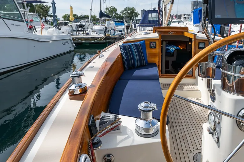 Slide: The Image of Luxurious 2009 Morris M36 sailboat interior with wooden accents and blue seating at a marina. - 33
