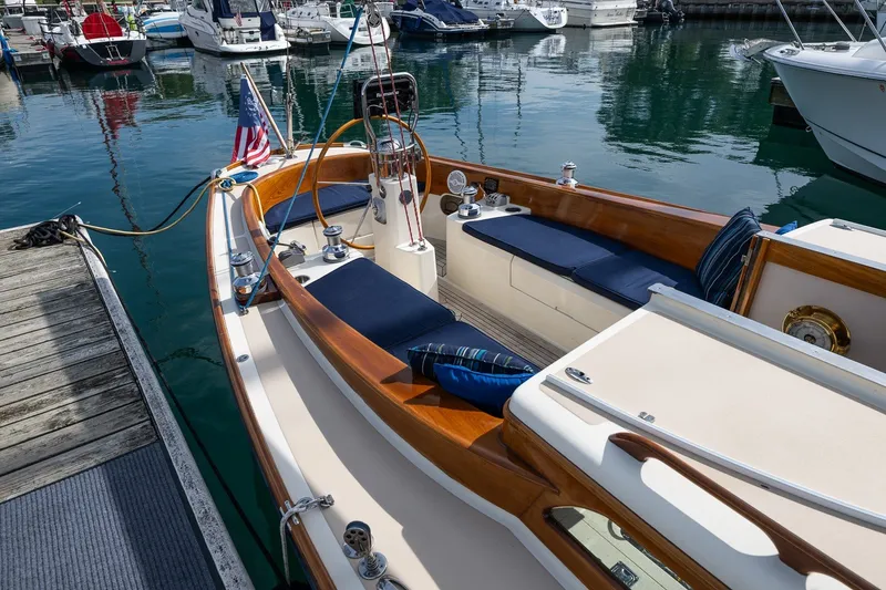 Slide: The Image of Elegant 2009 Morris M36 sailboat docked in marina, featuring wooden trim and blue cushions. - 25