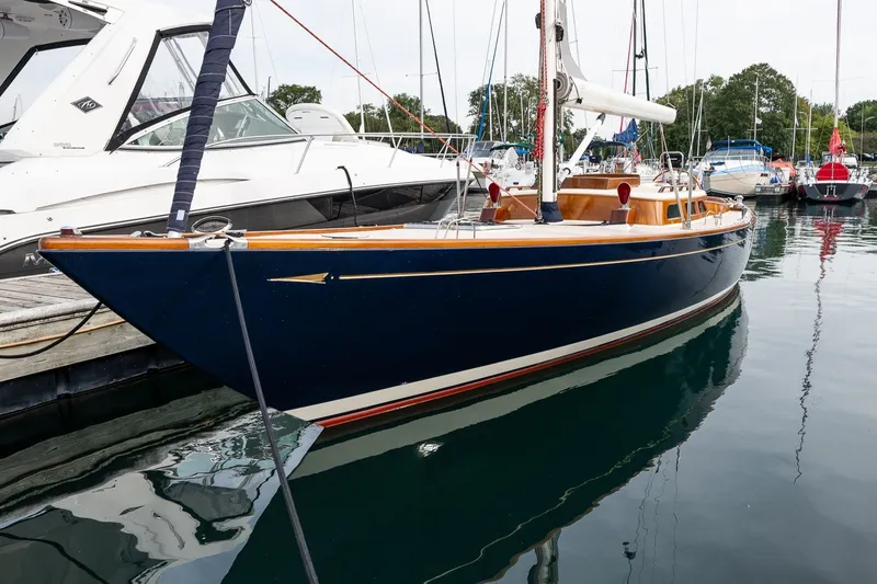 Slide: The Image of 2009 Morris M36 sailboat docked in a marina, featuring sleek design and wooden accents. - 3