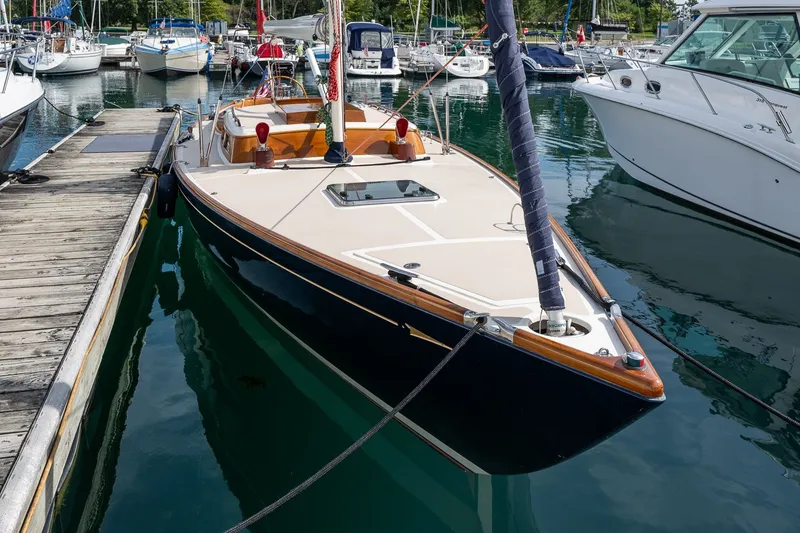 Slide: The Image of Sleek 2009 Morris M36 sailboat docked in a marina, surrounded by other boats. - 5