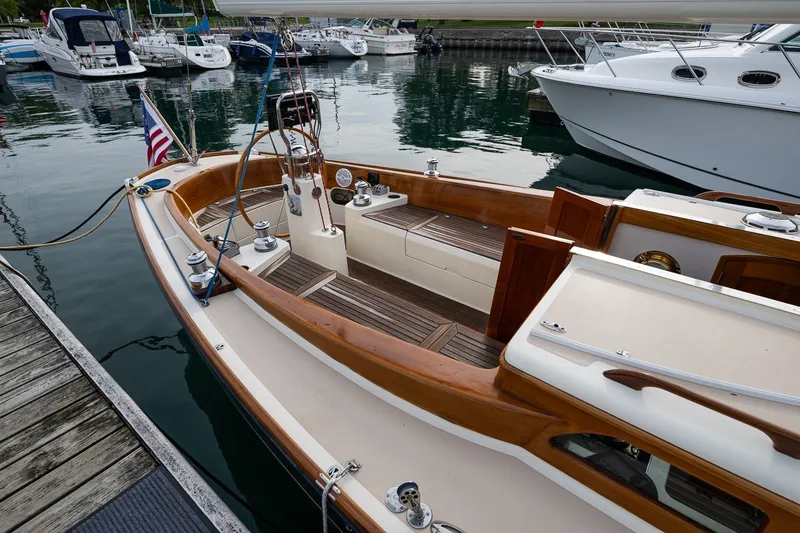 Slide: The Image of 2009 Morris M36 sailboat docked in marina, featuring elegant wooden deck and American flag. - 19