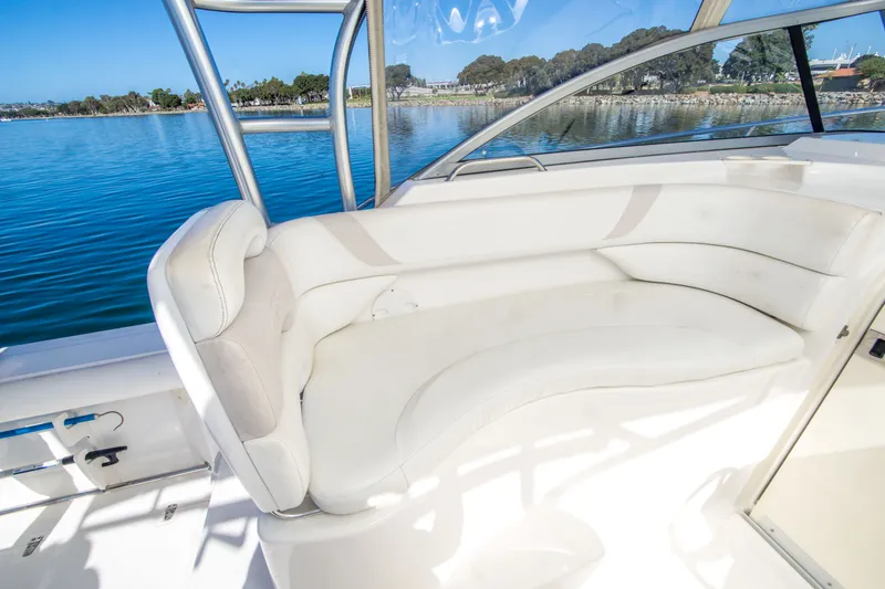 Slide: The Image of 2005 Boston Whaler 305 Conquest boat interior with white seating and scenic water view. - 21