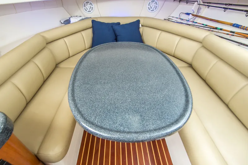 Slide: The Image of Interior of 2005 Boston Whaler 305 Conquest with cushioned seating and oval table. - 16