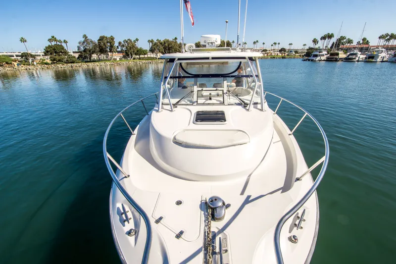 Slide: The Image of 2005 Boston Whaler 305 Conquest boat docked in a serene marina setting. - 7