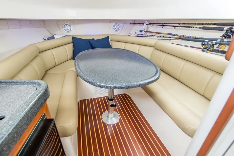 Slide: The Image of 2005 Boston Whaler 305 Conquest cabin with beige seating and fishing rods. - 17