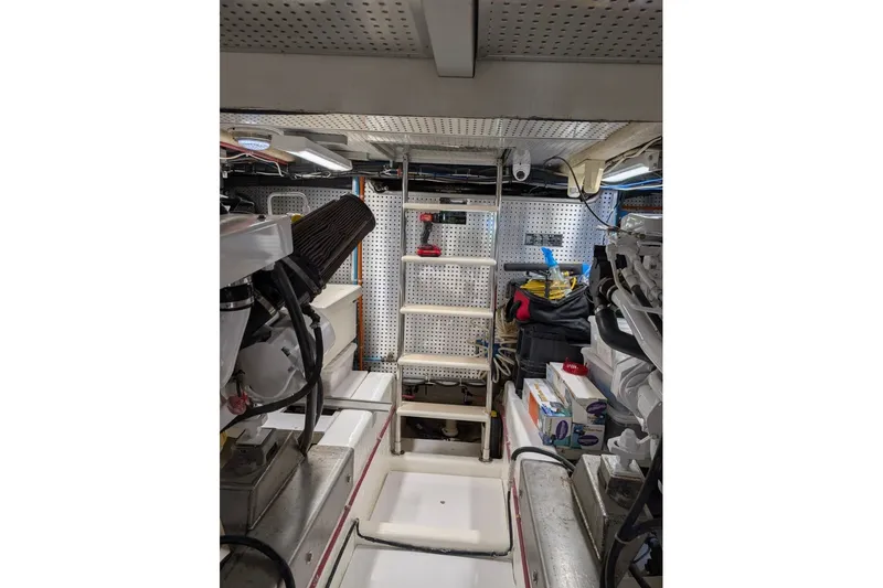 Slide: The Image of Engine room of a 1998 Offshore Yachts 54 Pilot House, featuring organized tools and equipment. - 18