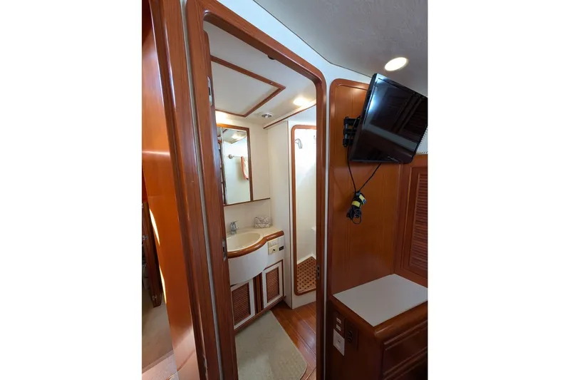 Slide: The Image of Interior of 1998 Offshore Yachts 54 Pilot House, featuring a bathroom with wooden accents. - 13