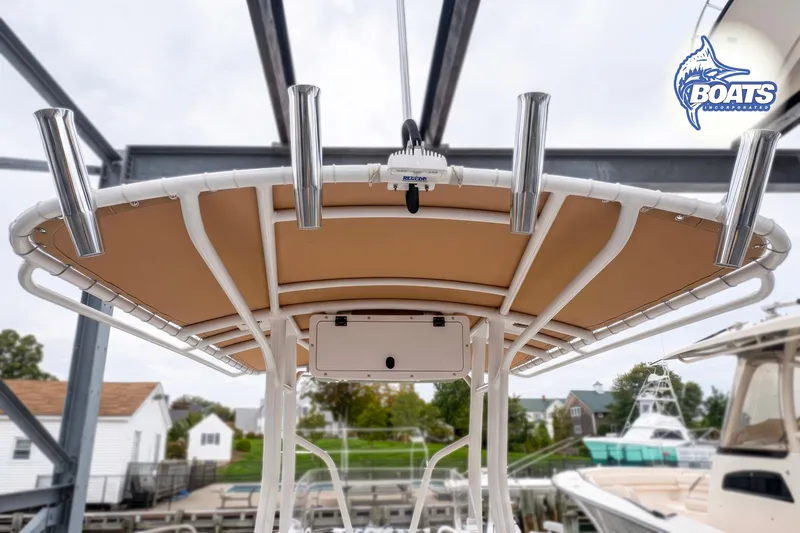 Slide: The Image of 2021 Edgewater 208CC boat with T-top and rod holders, docked at marina. - 6