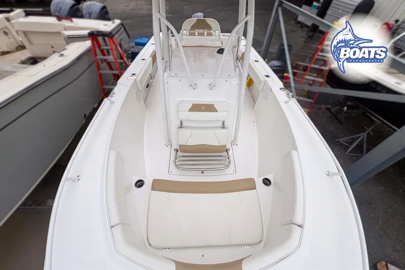 Slide: The Image of 2021 Edgewater 208CC boat interior with beige seating and white deck, viewed from above. - 5