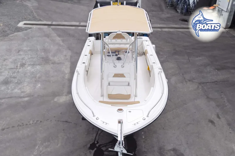 Slide: The Image of 2021 Edgewater 208CC boat with beige canopy, viewed from above in a showroom. - 2