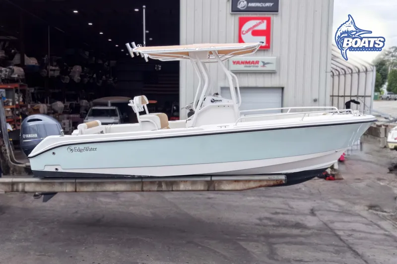 Slide: The Image of 2021 Edgewater 208CC boat with Yamaha engine, displayed at a marina workshop. - 3