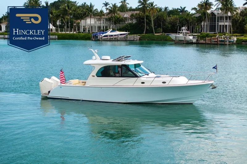 The Image of A sleek Hinckley Sport Boat 40 X on calm waters with a tropical backdrop. - 0