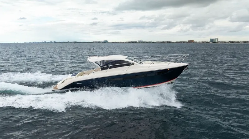 Slide: The Image of A 2013 Pursuit SC 365i Sport Coupe speeds across the sea, with a city skyline in the background. - 26