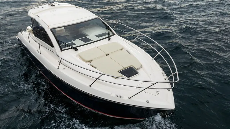 Slide: The Image of A sleek sport boat with an enclosed cabin cruising on choppy waters. - 29