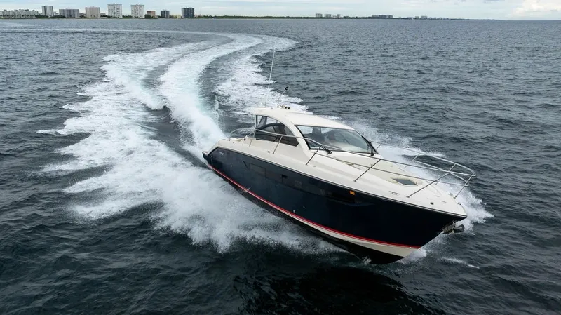 Slide: The Image of A 2013 Pursuit SC 365i Sport Coupe speeds across the water, with a city skyline in the background. - 21