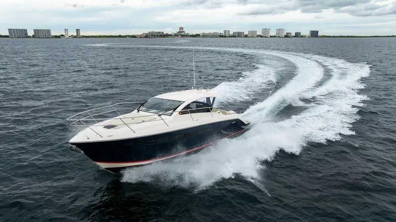 Slide: The Image of 2013 Pursuit SC 365i Sport Coupe on the water, with modern buildings in the background. - 20