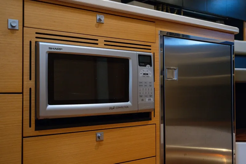 Slide: The Image of A microwave and refrigerator are built into a wooden cabinet wall. - 46