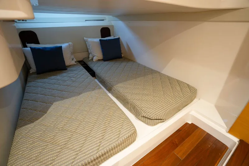 Slide: The Image of Two single beds with striped mattresses and blue pillows in a boat cabin. - 48