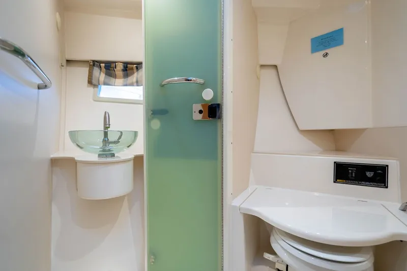 Slide: The Image of The image shows a modern boat bathroom with a glass sink and toilet. - 36