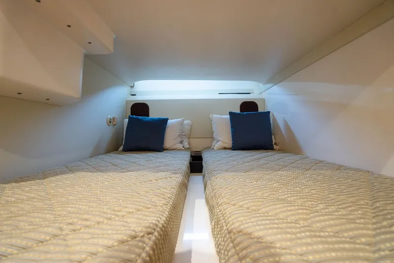 Slide: The Image of Two single beds with blue pillows in a cozy cabin with a skylight. - 49