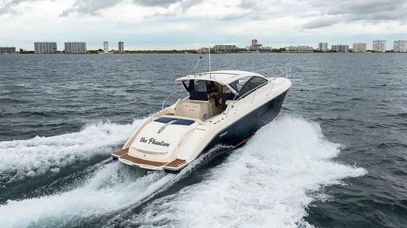 Slide: The Image of A 2013 Pursuit SC 365i Sport Coupe speeding on the water, with a city skyline in the background. - 27