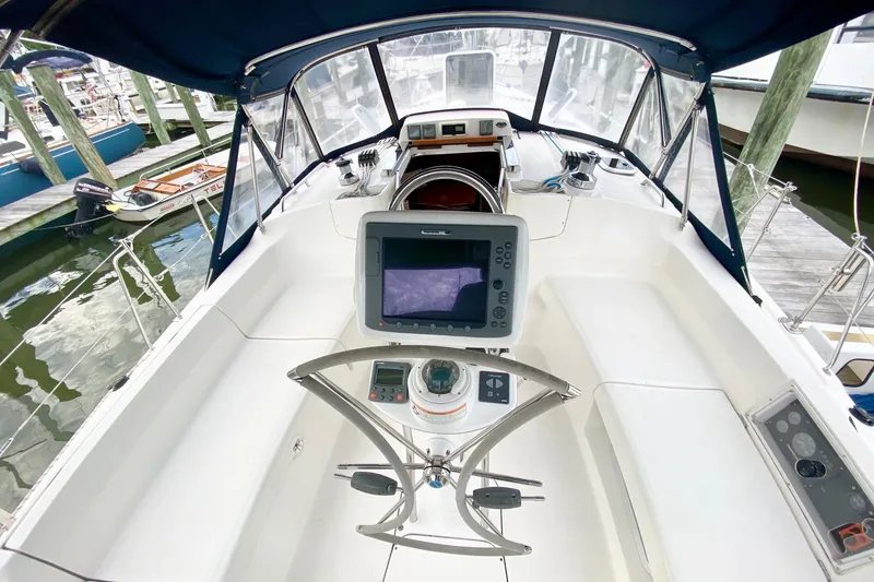 Slide: The Image of Cockpit of 2008 Hunter 41 Aft, featuring navigation equipment and steering wheel, docked at marina. - 51