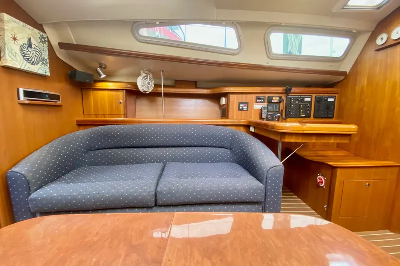 Slide: The Image of Interior of 2008 Hunter 41 Aft Cockpit yacht with blue sofa and wooden cabinetry. - 18