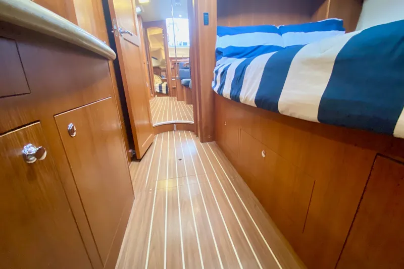 Slide: The Image of Interior of 2008 Hunter 41 Aft Cockpit yacht with wood finish and striped bedding. - 34