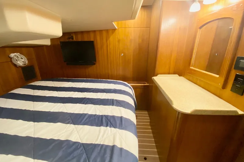 Slide: The Image of Cozy cabin interior of 2008 Hunter 41 Aft Cockpit with striped bedding and wood paneling. - 25