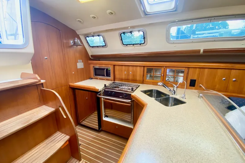 Slide: The Image of Luxurious 2008 Hunter 41 Aft Cockpit yacht interior with modern kitchen and wooden cabinetry. - 21