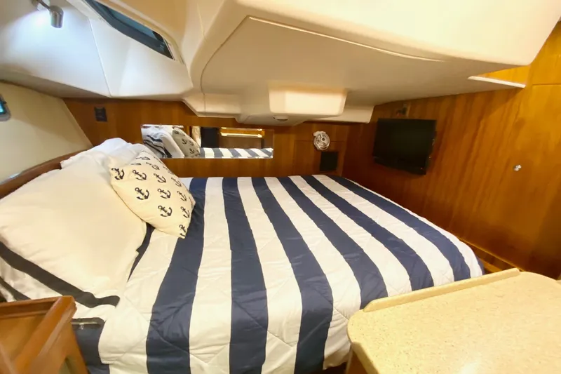 Slide: The Image of Aft cabin of 2008 Hunter 41 Aft Cockpit yacht with striped bedding and wood paneling. - 24