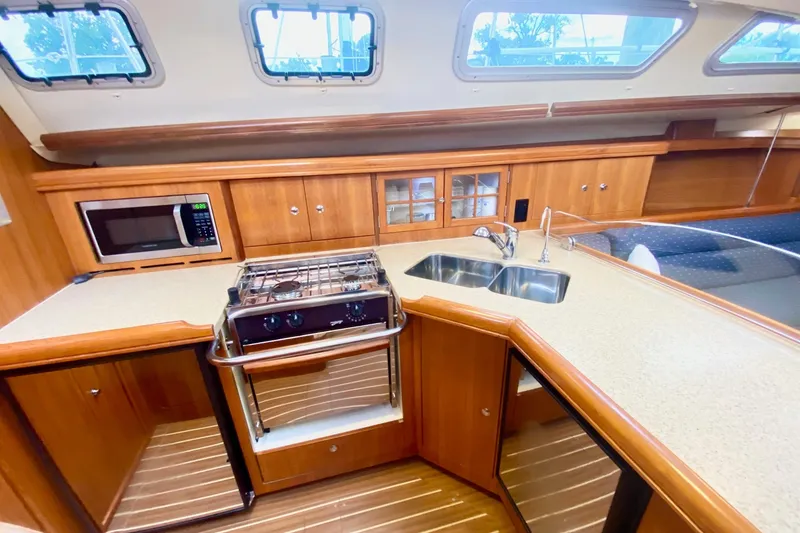 Slide: The Image of Luxurious 2008 Hunter 41 Aft Cockpit yacht kitchen with stove, microwave, and sink. - 22