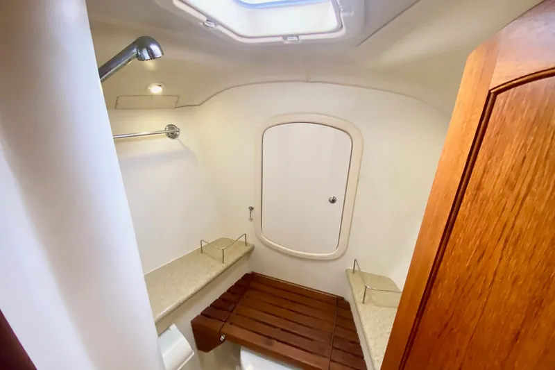 Slide: The Image of Interior of 2008 Hunter 41 Aft Cockpit yacht bathroom with shower and wooden bench. - 30