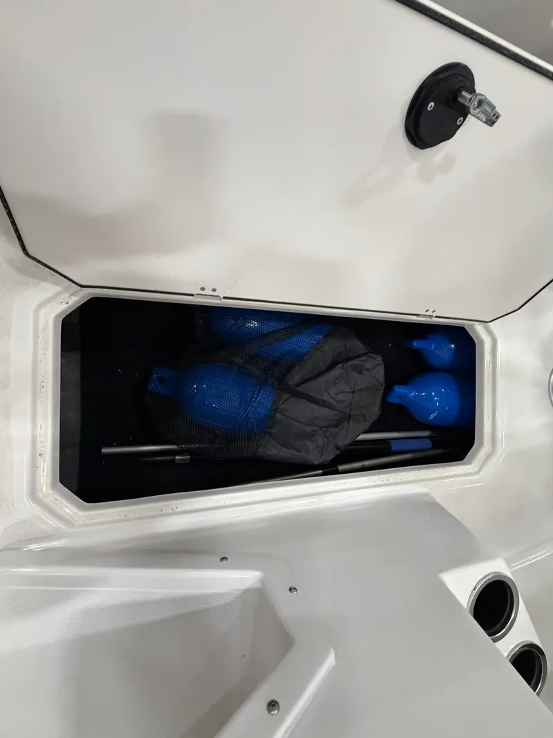 Slide: The Image of Storage compartment with blue fenders and a black bag inside the boat. - 28