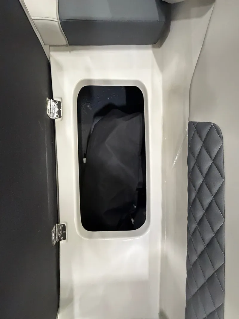 Slide: The Image of A storage compartment with cushioned seating and a black cover inside. - 26