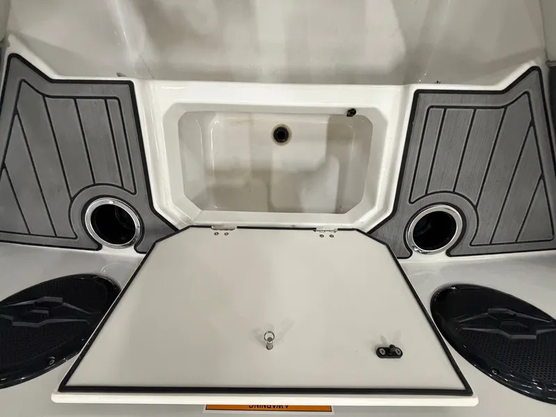 Slide: The Image of The image shows the rear area of a Starcraft SVX 171 OB boat with storage and speakers. - 23
