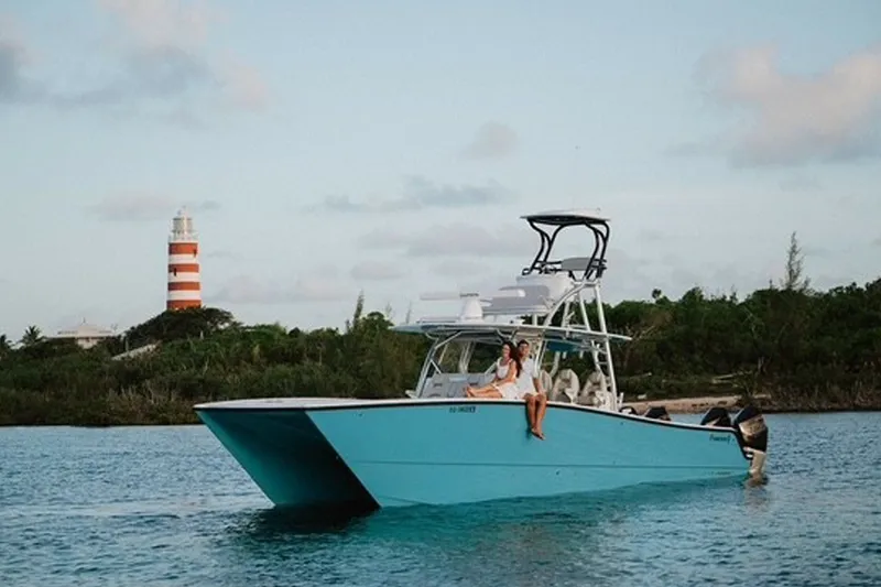The Image of 2024 Freeman 42LR boat cruising near a lighthouse, with passengers enjoying the view. - 1